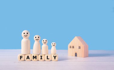 Aile sözleri ve tahta blokların üzerinde duran ahşap figürler ebeveynler ve çocuklardan oluşur. Aile birlikte koruma ve emlak ve ev sigortası ve emlak yatırım konseptini yönetmek.