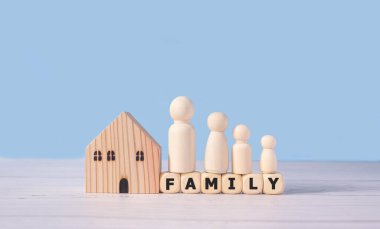 Aile sözleri ve tahta blokların üzerinde duran ahşap figürler ebeveynler ve çocuklardan oluşur. Aile birlikte koruma ve emlak ve ev sigortası ve emlak yatırım konseptini yönetmek.