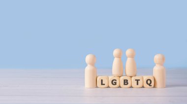 LGBT sözcüğü ahşap bloklar ve mavi arka plandaki ahşap figürler kuzenle olan insan ilişkisini temsil ediyor. Gökkuşağı aşkını kavra. İnsan hakları ve hoşgörüyü.