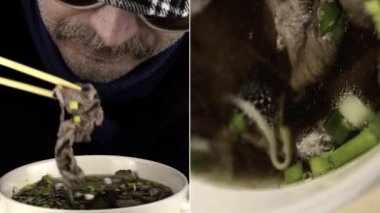 Pho bo. Bıyıklı bir adamın retro güneş gözlüğü taktığı ve ekoseli bir şapkayla kaseden pho bo çubukları yediği yakın plan. Sincap, sığır eti.
