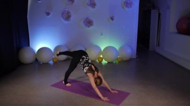 Tek bacak aşağı doğru. Eka Pada Adho Mukha Svanasana. Anjaneyasana. Yüksek Hamle Pozisyonu. Virabhadrasana 3.Savaşçı Pozu. Esnek, orta yaşlı bir sarışın fitness kulübünde yoga yapıyor. Paspasın üstünde Asya yogası yapıyor..