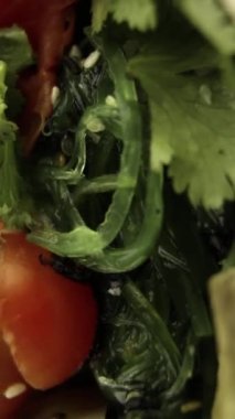 Avokado, otlar, vişneli domatesler, Chuca yosunlarıyla yakın çekim. Dikey video. Dikey.