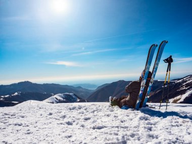 Kayak dağcısı bir dağın tepesinde dinleniyor.