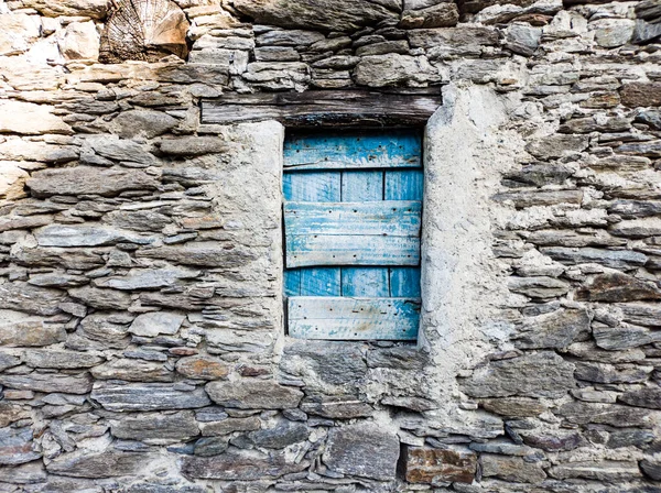 Blue window in a stone wall