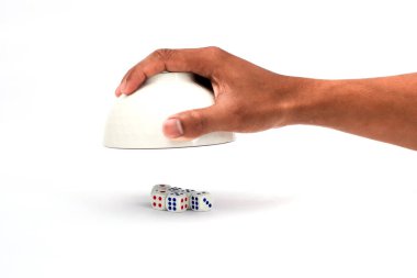Bir el, yumuşak stüdyo ile temiz beyaz bir yüzey üzerinde küçük bir domino grubunu kaplarken gösteriliyor.