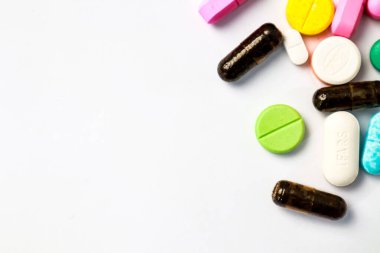 Farklı şekillerde çeşitli ilaç ve kapsüllerin toplanması. Renkler ve boyutlar dağınık.
