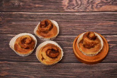 Lezzetli tarçınlı börekler ahşap bir yüzeye dizilmiş, keyif almaya hazır..