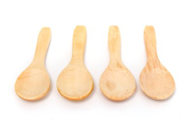 Dört kırsal ahşap kaşık, temiz beyaz bir zemine karşı yan yana sergileniyor..