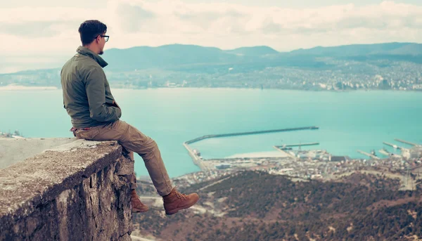 Mann sitzt über der Bucht — Stockfoto