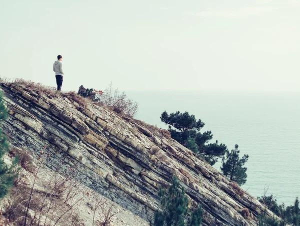 Young man standing on a rock outdoor — Stock Photo, Image