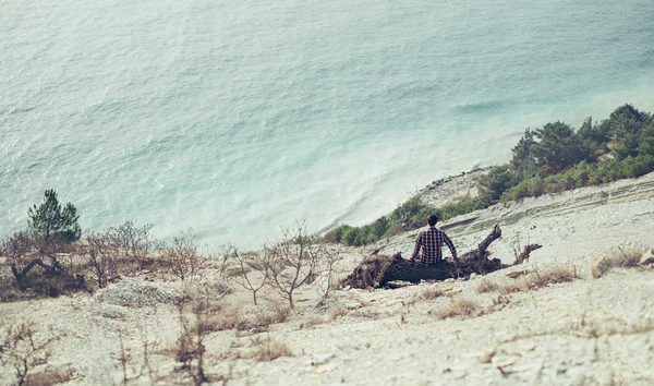 Budak kenarı üzerinde oturan adam