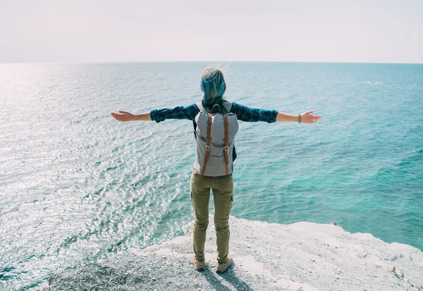 Happy explorer traveler girl standing on coast — Stock Photo, Image