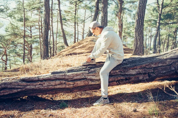Sportieve man schoenveters koppelverkoop in het bos — Stockfoto