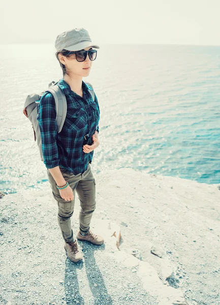 Улыбающаяся путешественница, стоящая на крутом берегу — стоковое фото