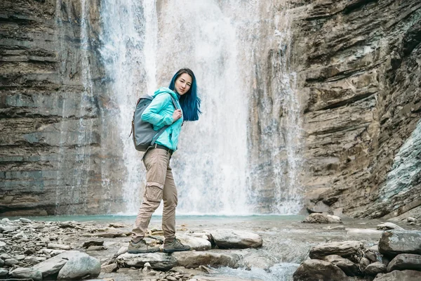 滝の背景に美しい旅行者の女の子 — ストック写真
