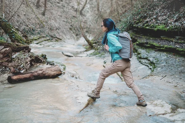 Hiker girl crossing the river — Stock Photo, Image