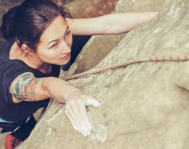 Girl climbing on rock clipart