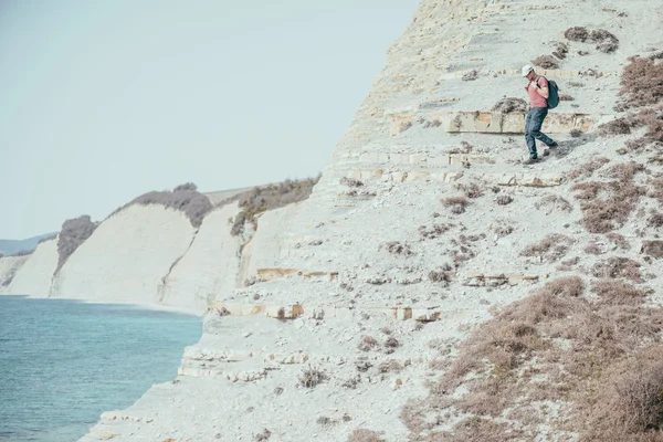 L'uomo scende su una costa scoscesa — Foto Stock