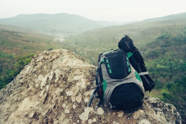 Backpack on peak of rock — Stock Photo, Image