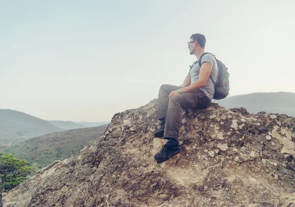 Hiker sitting on peak of rock — Stock Photo, Image