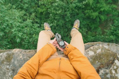 Pusula ile Cliff üzerinde oturan Gezgin 