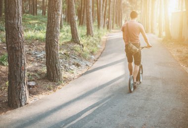 Genç adam tekme scooter üzerinde