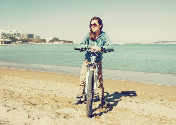 Girl with bicycle on beach — Stock Photo, Image