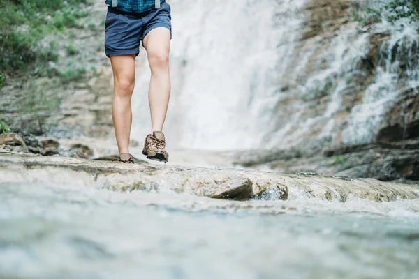 Chica excursionista cruzando el río — Foto de Stock