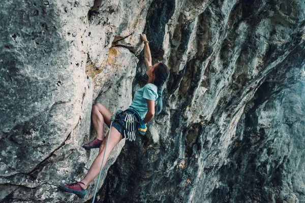 Женщина лезет на скалу — стоковое фото