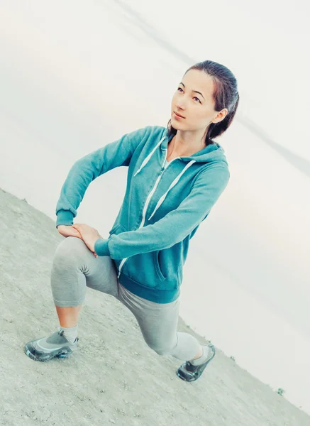 Fitness vrouw haar benen uitrekken — Stockfoto