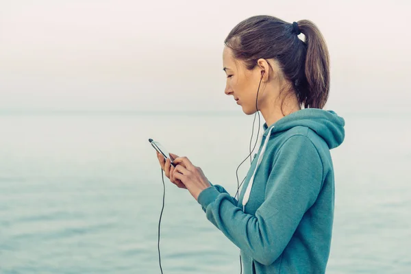 Mulher fitness escolhe a música — Fotografia de Stock