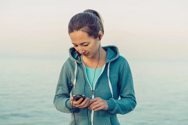 Fitness girl chooses the music — Stock Photo, Image