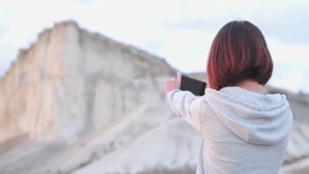 若い女性が写真を撮ったり Kayaの白い岩のビデオを撮影したり クリミア 旅行とブログの概念 — ストック動画