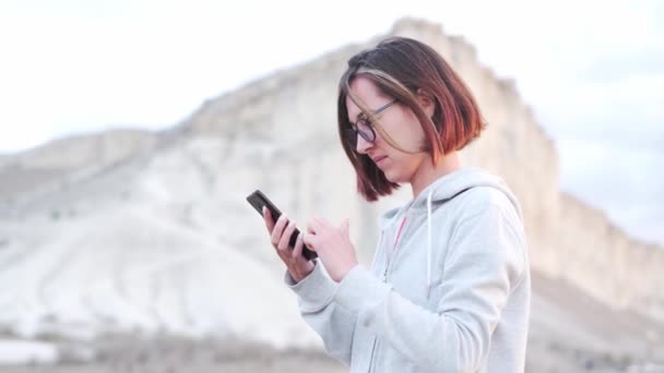 克里米亚Ak Kaya白色岩石背景下使用智能手机的女旅行者 — 图库视频影像