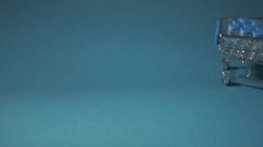 Tıbbi eldivendeki bir el, aşıyla dolu bir sepeti yuvarlar. Aşı teslimatı konsepti.