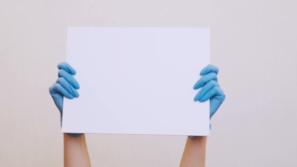 Mãos Femininas Luvas Médicas Segurando Cartaz Branco Branco Espaço Cópia — Vídeo de Stock