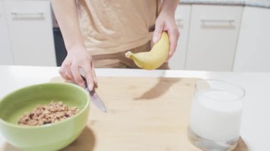 Genç bir kadın hafif bir şeyler hazırlamak için muz soyar.. 