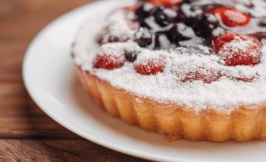 Tahta bir masada çilek ve kirazlı basit ev yapımı turta..