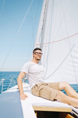 Yattaki genç bir adamın portresi. Hafta sonu yelken gezisi.