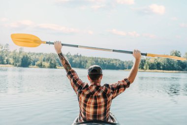 Genç adam nehirde seyahat eder. Arkadan bak. Kürek kalkıyor. Seyahat özgürlüğü kavramı.