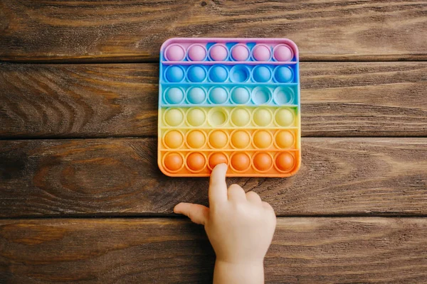 El niño juega con el popular juguete simple hoyuelo. — Foto de Stock