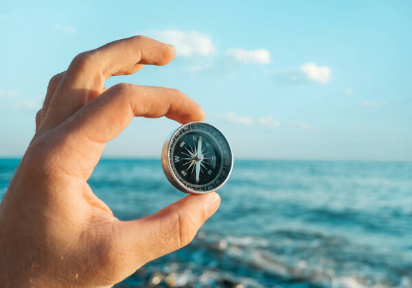 Compass in the hand of a male tourist.