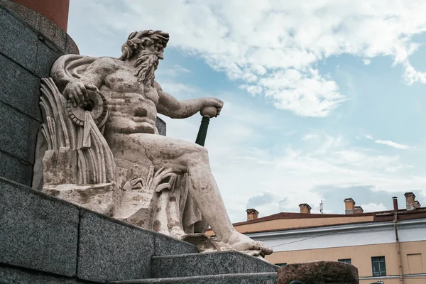 Forntida romersk staty av en havsgud vid foten av Rostral kolumner närbild mot bakgrund av himlen. — Stockfoto