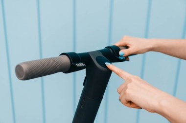 Caddedeki elektrikli scooter 'ı açan ya da kapatan kadın..