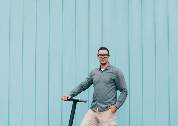 Man in shirt standing with e-scooter in street. — Stock Photo, Image