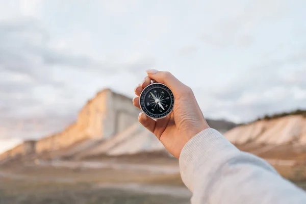 In female hands Compass in the background, mountain Cliff White. — Stock Photo, Image