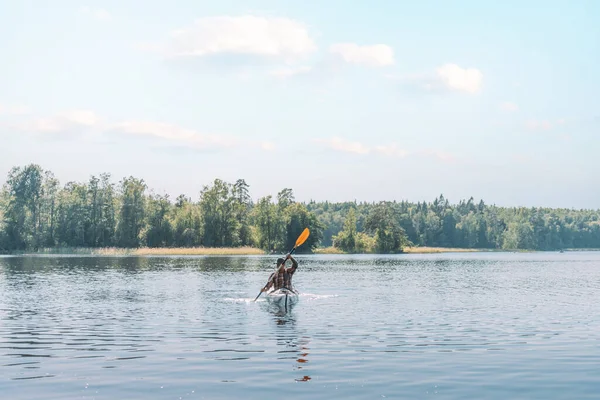 Unge man simmar ensam på en båt vid floden. — Stockfoto