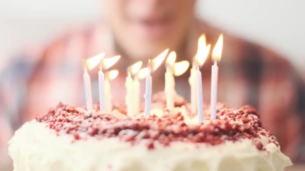 Un hombre irreconocible apaga las velas de un pastel de cumpleaños. — Vídeos de Stock