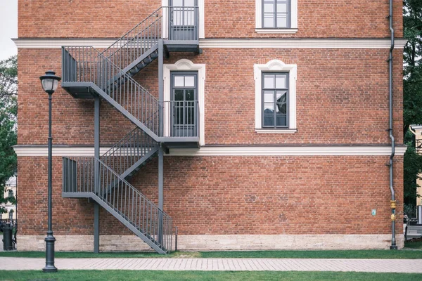 Parede de tijolo de uma casa com uma escadaria de ferro vintage. — Fotografia de Stock