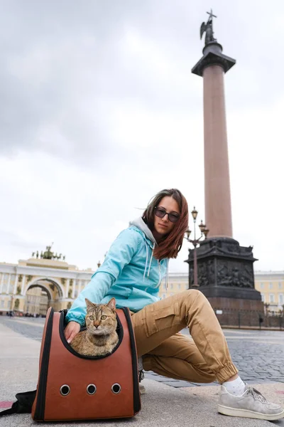 Katt resenären med en ung kvinna på bakgrunden av sevärdheterna i Sankt Petersburg. — Stockfoto